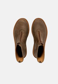 Botas de cuero marrón hasta el tobillo con cierre de cremallera, punta redondeada y suela en contraste color tostado. Presentan un acabado suave y un diseño sencillo.
