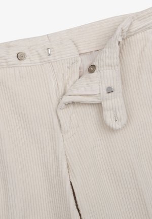 Pantalones de pana blanca con cremallera, dos botones metálicos y una abertura lateral. Tejido texturizado con patrón de estrías verticales.