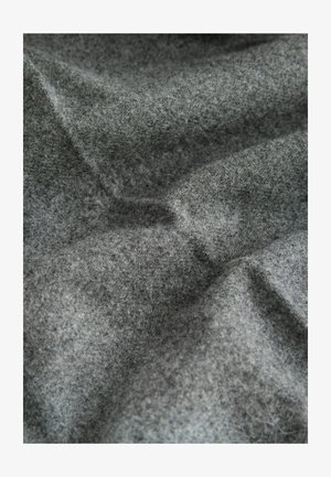 Siva filcasta tkanina z mehko, teksturno površino, ki prikazuje subtilne razlike v odtenku in nekoliko grob videz.