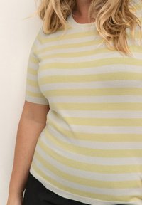 Pasiasty sweter z dzianiny w jasnym żółtym i szarym kolorze. Posiada krótkie rękawy, okrągły dekolt i dopasowany krój. Miękka tekstura i minimalistyczny design.