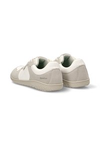 Zapatos de ante gris claro con acentos blancos, forma redondeada, suela texturizada y detalle de marca en el talón. Diseño con cordones y collarín acolchado.