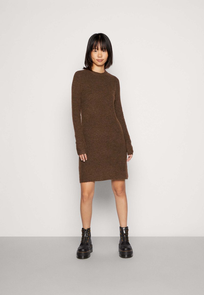 Brown knitted dress with long sleeves and a round neckline. Features a slightly fitted silhouette and a hem that falls above the knee.
