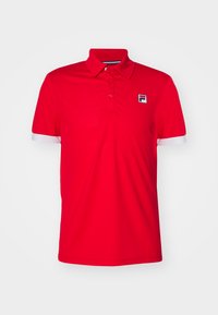 T-shirt polo rouge en tissu lisse avec un col classique, des poignets blancs et un petit logo dans le coin supérieur gauche. Design simple et fonctionnel.