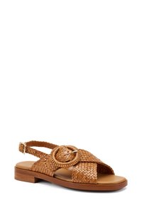 Sandalo in pelle intrecciata di colore marrone chiaro con una fibbia arrotondata, punta aperta e tacco in legno basso. Presenta una cinturino regolabile sul tallone.