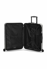 Maleta rígida en plata con interior negro. Cuenta con un mango telescópico, cuatro ruedas y bolsillos de malla internos para organización.