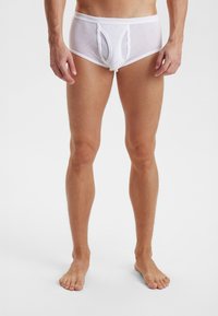 Hvide ribbede herreboksershorts med åbning foran, lavet af et åndbart materiale. Har en bred elastik i taljen og en tætsiddende pasform.