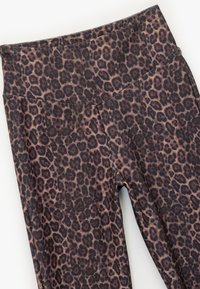 Leopard print leggings with a high waistband, featuring shades of brown and black on a stretchy, soft fabric. Smooth texture and seamless design.