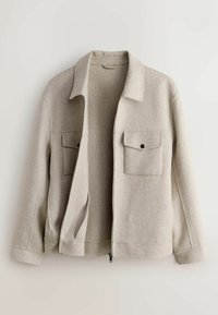 Veste en laine beige clair avec fermeture éclair avant ouverte, deux poches à rabat sur la poitrine avec boutons, et manches longues sur fond neutre.