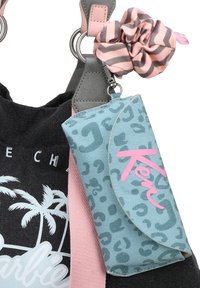 Pochette à motif léopard bleu avec le texte "Ken" en rose, attachée à un sac noir avec un design de palmier et une bandoulière rose pastel. Inclut un chouchou rayé rose et gris.