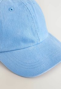 Helles blaues Baumwoll-Baseballcap mit einem gebogenen Schild, strukturiertem Stoff und gestickten Details entlang des Randes und an der Oberseite.