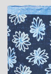 Granatowy materiał z dużymi jasnoniebieskimi wzorami kwiatowymi z teksturowanymi konturami. Górna krawędź jest jasnoniebieska, co kontrastuje z ciemniejszym tłem.