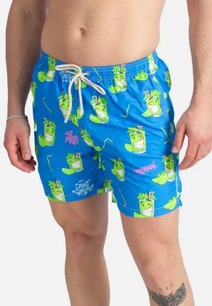 Pantaloni da bagno blu con un motivo di cocktail verdi in stile cartoon con fette di lime e cannuccia, fissati con un laccio bianco in vita.