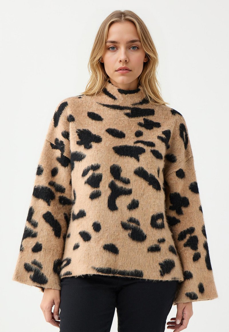 Beiger Pullover mit schwarzen Leopardenflecken, hohem Kragen und weiten Ärmeln, aus einem weichen, strukturierten Stoff, mit geribbeltem Saum.