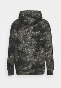 Sweat à capuche tie-dye noir et gris vu de dos, avec manches longues et poignets et ourlet côtelés.