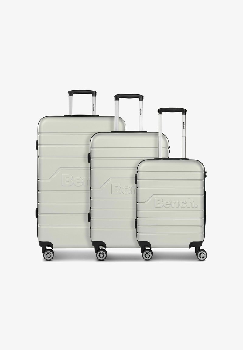 Set di tre valigie rigide di color grigio chiaro con una finitura testurizzata, dotate di maniglie estensibili e quattro ruote per la mobilità.