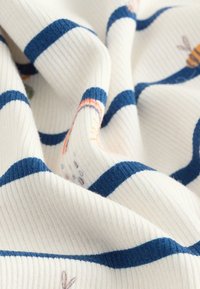 Weißer Stoff mit blauen Streifen und kleinen, eingestickten Bienenmustern. Gerippte Textur verleiht dem Design Tiefe. Weiches und leichtes Material.