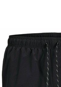 Schwarze Badeshorts mit elastischem Bund und Kordelzug. Der Stoff ist glatt mit einem leichten Glanz und reflektierenden Akzenten an den Kordeln.