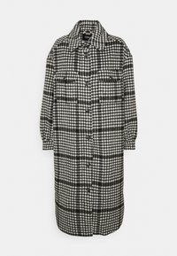 Černobílé kostkované oversized košilové sako s límcem, zapínáním na knoflíky a dvěma kapsami na hrudi. Vyrobeno z texturované látky.