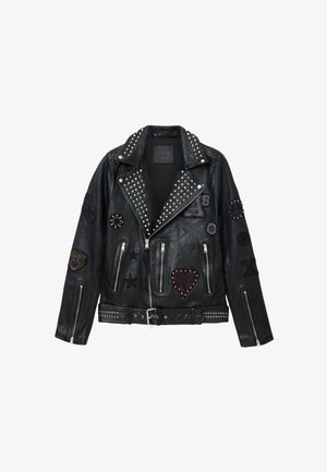Čierna kožená motorkárska bunda so striebornými cvokmi, zipsami a rôznymi nášivkami vrátane srdca, hviezd a zvieracích motívov.