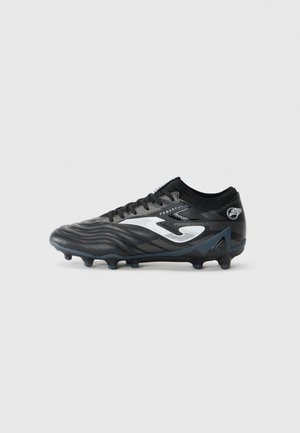 Black soccer cleat with textured upper, white branding, and patterned design. Features rubber studs for traction on grass surfaces.