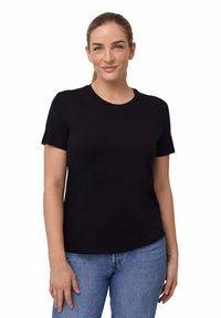Sort kortærmet t-shirt lavet af bomuld med rund halsudskæring, parret med blå denimjeans. T-shirten har en afslappet pasform og ingen synlige mønstre.