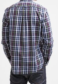 Langärmliges kariertes Hemd mit blauen, grünen, roten und weißen Karos; Button-Down-Kragen; und zwei Knopfmanschetten mit weißen Knöpfen.