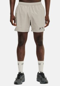 Helle grau Sportshorts mit elastischem Bund, Seitentaschen und schwarzem "ATW"-Logo am linken Oberschenkel; kombiniert mit schwarzen Sneakers und weißen Socken.