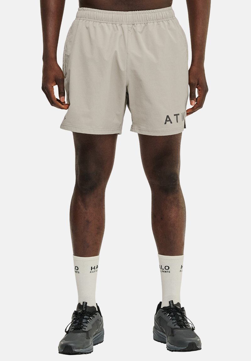 Helle grau Sportshorts mit elastischem Bund, Seitentaschen und schwarzem "ATW"-Logo am linken Oberschenkel; kombiniert mit schwarzen Sneakers und weißen Socken.