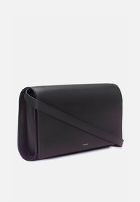 Sac bandoulière rectangulaire en cuir noir avec rabat et fine bandoulière, petit logo doré "Vince" sur le devant.