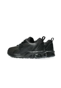 Chaussures de sport noires avec une tige en mesh et synthétique, des détails texturés, un col rembourré et une semelle en caoutchouc avec des éléments de rembourrage visibles.