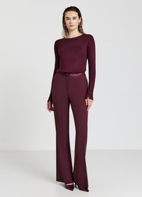 Burgunderfarbener Langarmoberteil, kombiniert mit passender hochtaillierter, ausgestellter Hose. Glattes Material mit feinem Finish und subtiler Eleganz.