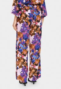 Cvečne široke hlače v živahni mešanici roza, vijolične, rjave in modre barve z svilnato teksturo in elastičnim pasom.