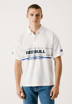 Hvid polo skjorte med "RED BULL RACING" trykt i grøn og blå, har grå vandrette striber, korte ærmer og en klassisk krave.