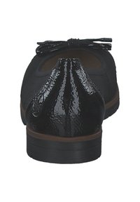 Ballerines noires en cuir avec un bout texturé et brillant et un détail en nœud. Talon bas et semelle marron, présentant une forme arrondie et un intérieur lisse.