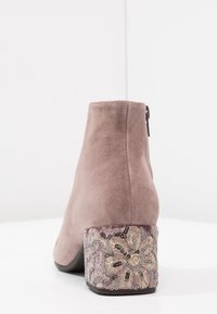 Jasnoszare botki za kostkę z gładką zamszową cholewką i zdobionym, wzorzystym obcasem w kształcie bloku, z kwiatowymi wzorami w złotych i srebrnych nitkach.