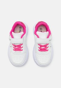 Weiße Sportschuhe mit pinken Schnürsenkeln und Innenfutter, ausgestattet mit einem Klettverschluss, perforiertem Design und einer strukturierten Gummisohle.
