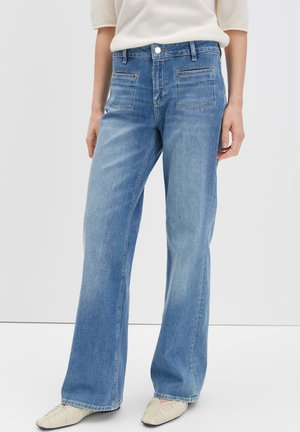Lichtblauwe wijde jeans van denim. Voorzien van voor- en achterzakken, een knoopsluiting en een gladde textuur.