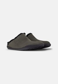 Grå ruskinds slip-ons med sort faux fur-foring og mørke gummisåler, der har et enkelt design og synlig syning.