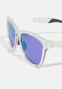 Klarsicht-Sonnenbrille mit verlaufenden lila Gläsern, die ein elegantes Design und strukturierte Bügel für besseren Halt aufweist.
