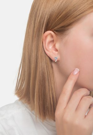 Silberne Ohrstecker in Herzform, verziert mit bunten Edelsteinen. Einfaches Design mit glatter Oberfläche und minimalistischen Stil.