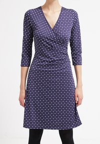 Fialové oblé šaty s diamantovým vzorem v bílé barvě, se třičtvrtinovými rukávy a rozšířenou sukní, vyrobené z měkké a elastické látky.