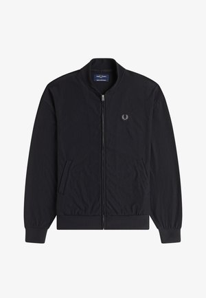 Chaqueta negra de pana con cremallera, cuello, puños y dobladillo acanalados, que cuenta con dos bolsillos delanteros y un pequeño logo bordado en el pecho.