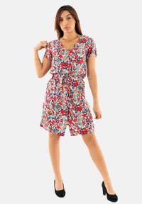 Vestido corto de flores con mangas cortas en vibrantes tonos rojos, azules y verdes. Presenta una cintura con lazo, escote en V y un corte holgado con textura de tela suave.