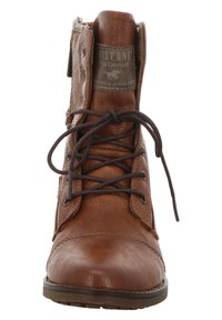 Botte cheville en cuir brun avec lacets, bout arrondi et détails de couture. Présente une surface texturée et un patch logo sur la languette.