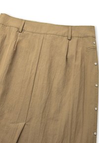 Gonna plissettata beige con un tessuto testurizzato, dotata di una vita alta e bottoni a pressione argentati lungo il lato.