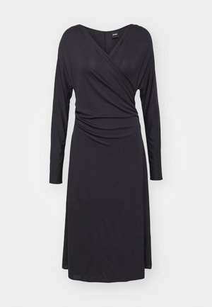 Vestido negro de envoltura con mangas largas, escote en V y detalle drapeado en el costado. Tela suave y ligera con un corte hasta la rodilla.