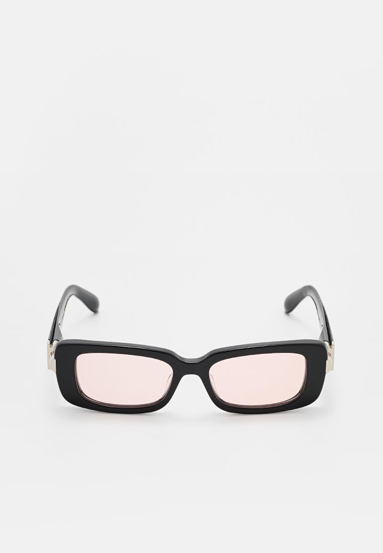Gafas de sol rectangulares negras con lentes rosas, presentan un marco grueso y un sutil acento plateado en las patillas. Acabado suave y diseño moderno.