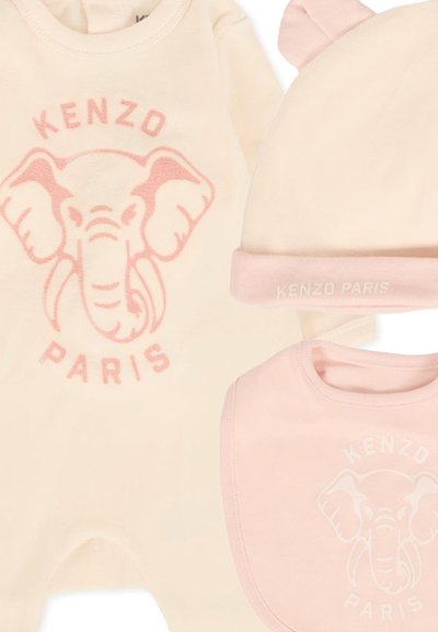 Il set per bambini Kenzo Paris include una tutina crema con un design di un elefante rosa, un bavaglino rosa e un cappellino abbinato con orecchie, tutti realizzati in morbido tessuto.