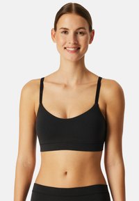 Sort bralette med tynde stropper, rund halsudskæring og sømløst design. Fremstillet af blødt, strækbart stof for komfort. Ingen synlig hardware.