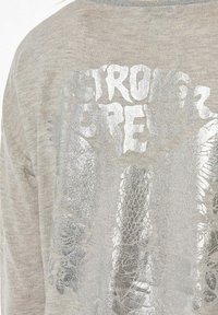 Lichtgrijs longsleeve shirt met een gestructureerde zilveren grafische print met de tekst "STRONG" en ingewikkelde details, van zachte stof.